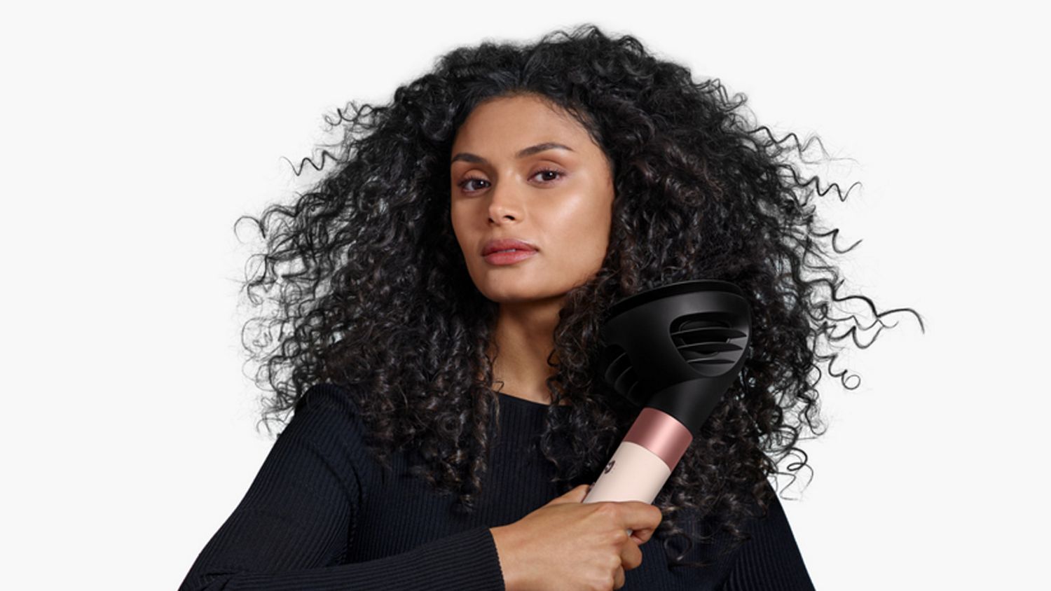 Model holding the Dyson Airwrap ID multi-styler and dryer with the Diffuser.
